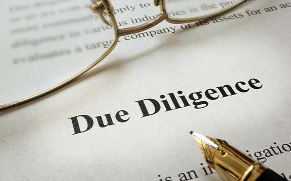 Page of paper with words Due Diligence and glasses